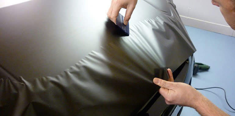 gray vehicle vinyl wrap application on car hood